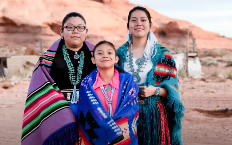 Imagen de tres miembros de la comunidadd de indios americanos y nativos de Alaska.